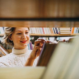 young-woman-choosing-book-library